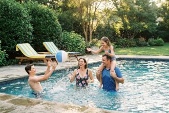 Famille s'amusant ensemble dans une piscine de jardin le week-end en été