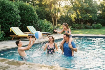 Famille s'amusant ensemble dans une piscine de jardin le week-end en été